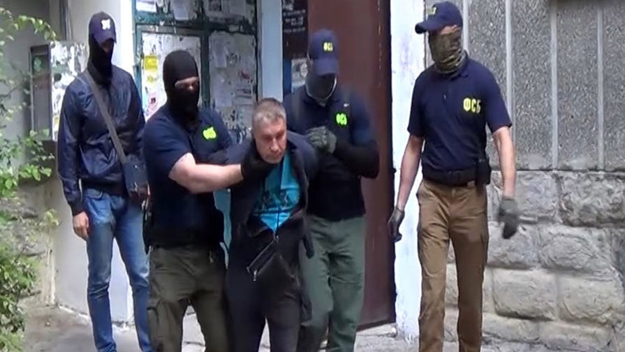 Сотрудники ФСБ во время задержания российского военнослужащего Дмитрия Долгополова (в центре) по подозрению в шпионаже в пользу Украины
