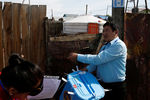 Члены избирательной комиссии с урной для голосования по открепительным удостоверениям у одного из домов в Монголии
