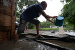 Мужчина вычерпывает воду из подъезда на затопленной улице Уссурийска
