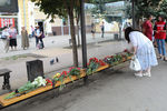 Женщина возлагает цветы к месту гибели людей в результате взрыва автобуса в Воронеже, 13 августа 2021 года