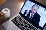 Жительница Новосибирска смотрит трансляцию одиннадцатой большой ежегодной пресс-конференции президента России Владимира Путина
