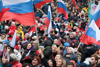 Посетители перед началом митинг-концерта «Россия объединяет!» на большой спортивной арене «Лужники» в Москве.