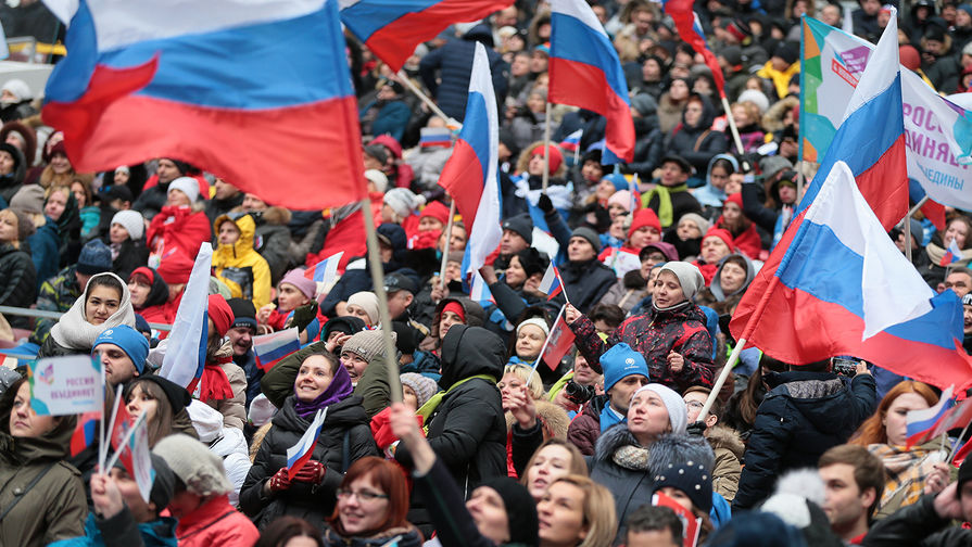 Посетители перед началом митинг-концерта «Россия объединяет!» на большой спортивной...