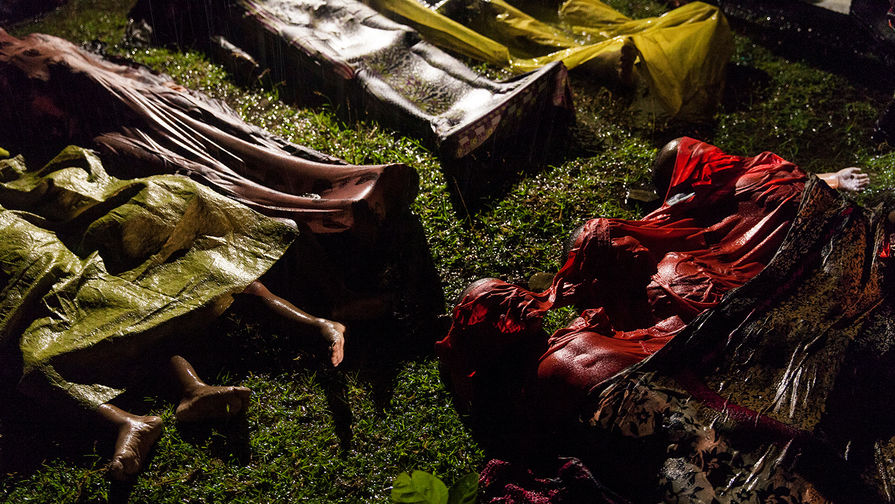 Фото сделано австралийским фотографом Патриком Брауном на одном из пляжей Бангладеша, недалеко от которого перевернулась лодка с рохинджа, которые пытались бежать из Мьянмы. Всего в лодке было около ста человек, выжило всего семнадцать; Браун сделал фото тел, подготовленных к транспортировке.