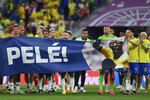 Сборная Бразилии держит плакатом с изображением Пеле после матча против сборной Южной Кореи, декабрь 2022 года