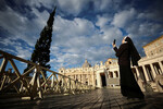 Монахиня снимает на телефон как рождественскую елку ставят на площади Святого Петра в Ватикане, 23 ноября 2023 года