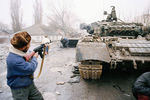 Жители Чечни около подбитых российских танков на одной из улиц Грозного, 1 января 1995 года