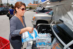 Женщина загружает бутылки с водой в багажник своего автомобиля. Майами, тат Флорида, США. 5 сентября 2017 года