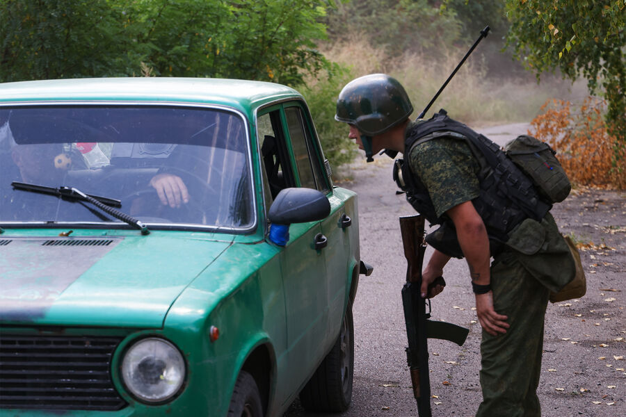 Военнослужащий Народной милиции ДНР проверяет проезжающую машину