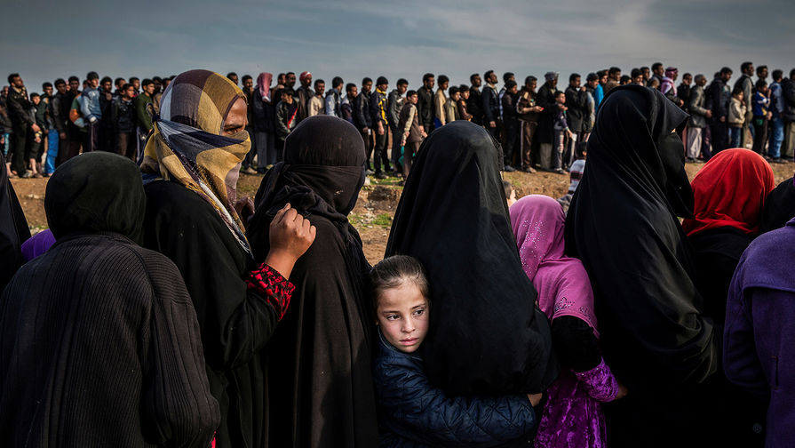 Оставшиеся в Мосуле (Ирак) гражданские лица стоят в длинной очереди за гуманитарной помощью.