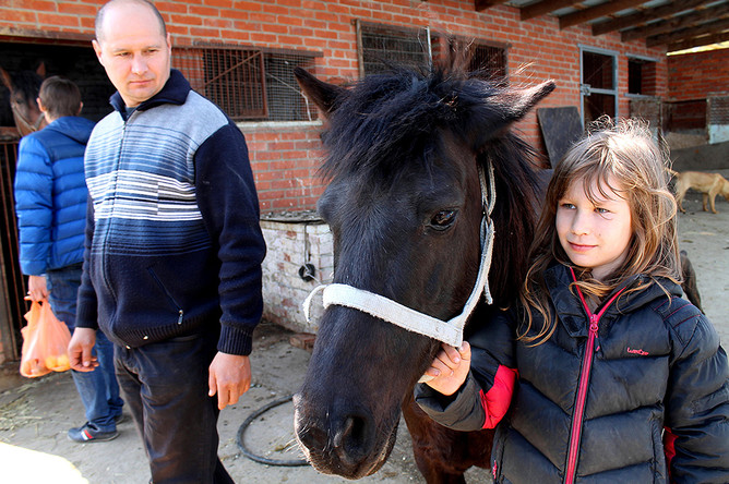 Игорь Чередий с дочерью и одной из спасенных лошадей