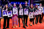 Гости Берлинского кинофестиваля держат фотографии девяти жертв стрельбы в городе Ханау четыре года назад, 15 февраля 2024 года
