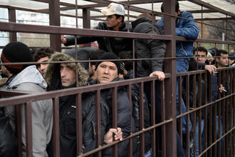 Граждане иностранных государств стоят в очереди в центральное отделение УФМС РФ по Москве