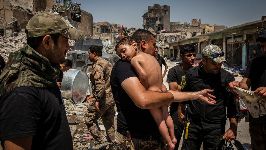 Солдат сил специального назначения иракской армии выносит маленького мальчика из последнего района, который контролируется боевиками «Исламского государства» (запрещенная в России организация), Мосул, Ирак.