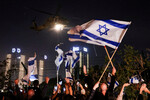 Люди машут израильскими флагами, приветствуя вертолет с отпущенными «Хамасом» заложниками, Израиль, 24 ноября 2023 года 