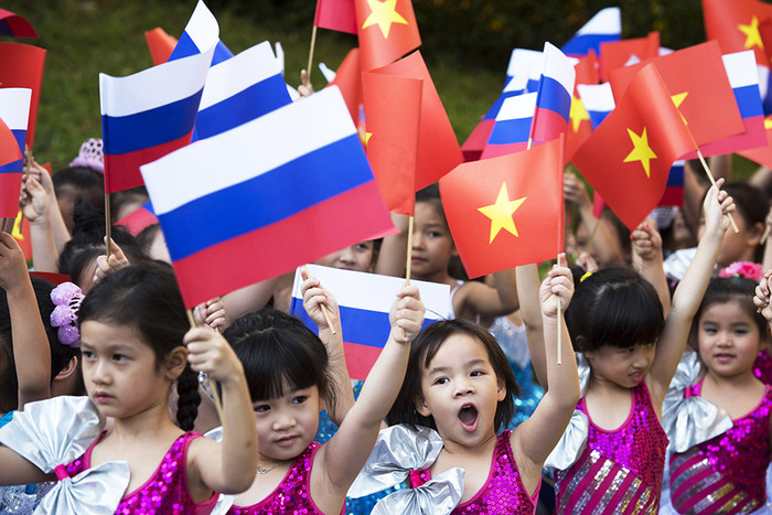 Дети с флагами России и Вьетнама на церемонии официальной встречи президента России на площади перед Президентским дворцом в Ханое