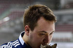 Сотрудник хоккейного клуба «Адмирал» Михаил Быков держит в руках кошку, ставшую талисманом хоккейного клуба «Адмирал»