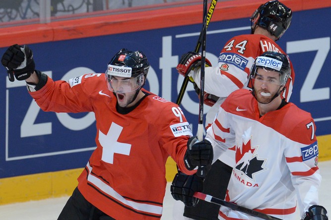 Игрок сборной Швейцарии Юлиан Уолкер празднует гол партнера в ворота Канады