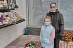 Сергей Будницкий с внучкой около стены памяти с фотографиями погибших при захвате Театрального центра на Дубровке