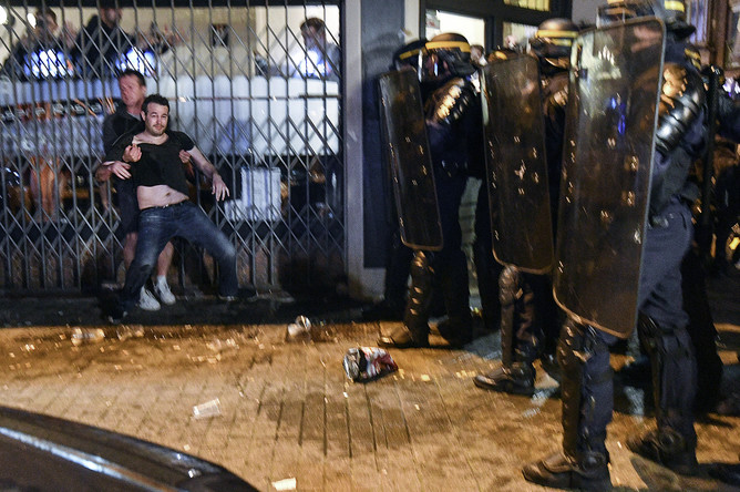 Сотрудники полиции и болельщики во время беспорядков на одной из улиц Лилля