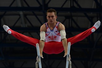 Российский гимнаст Давид Белявский выполняет упражнение на брусьях