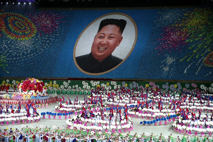 Участники представления держат карты, образуя портрет северокорейского лидера Ким Чен Ына, во время массовых игр под названием «Земля народа» на первомайском стадионе в Пхеньяне, Северная Корея, 11 сентября 2019 года