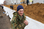 Местный житель во время установки водоналивных дамб на улице Галкинской, 14 апреля 2024 года