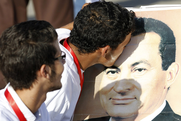 Сторонники Хосни Мубарака целуют его портрет перед&nbsp;зданием Полицейской академии в&nbsp;Каире, где проходит суд над&nbsp;отставленным президентом.