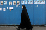 Иранская женщина проходит мимо плакатов предвыборной кампании на парламентских выборах в Тегеране, Иран, 27 февраля 2024 года