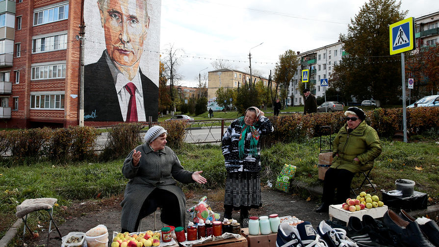 Уличная торговля на фоне портрета Владимира Путина на одном из домов в подмосковной Кашире, 10 октября 2017 года
