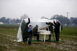 Китайский диссидент, художник Ай Вэйвэй, укрывает от дождя сирийскую беженку, играющую в&nbsp;поле на&nbsp;пианино возле импровизированного лагеря на&nbsp;греко-македонской границе возле деревни Идомени, Греция