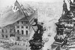 Бойцы 8-й гвардейской армии РККА Алексей Ковалев, Абдулхаким Исмаилов и Леонид Горичев (слева направо) с красным знаменем на крыше здания Рейхстага после взятия города советскими войсками, 2 мая 1945 года