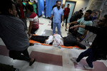 Раненому оказывают помощь после взрыва в больнице Аль-Ахли в Газе, 17 октября 2023 года