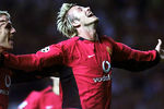 Дэвид Бекхэм радуется, забив мяч во время отборочного матча Лиги чемпионов УЕФА в Манчестере. 2002 год
