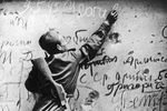 Советский солдат оставляет надпись на стене Рейхстага, май 1945 года