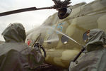 Солдаты в защитных костюмах проводят дезактивацию вертолета