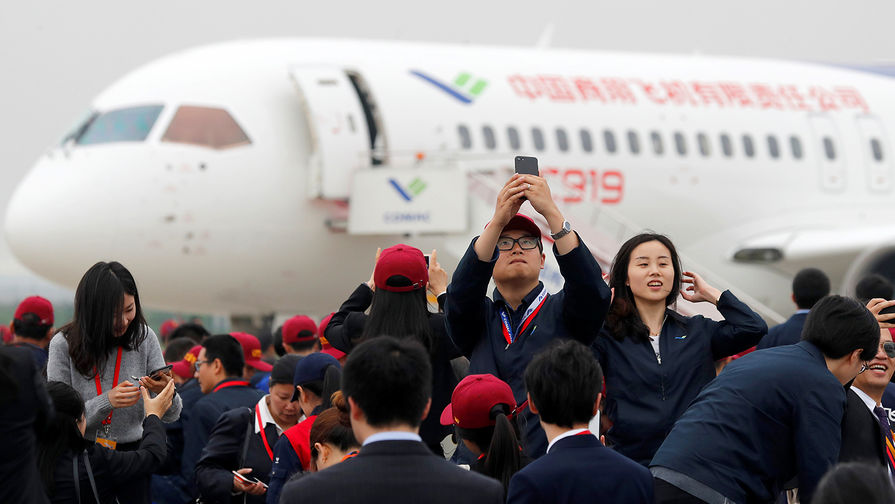 Участники церемонии фотографируются на&nbsp;фоне самолета C919 после его успешной посадки в&nbsp;аэропорту Шанхая, 5 мая 2017 года