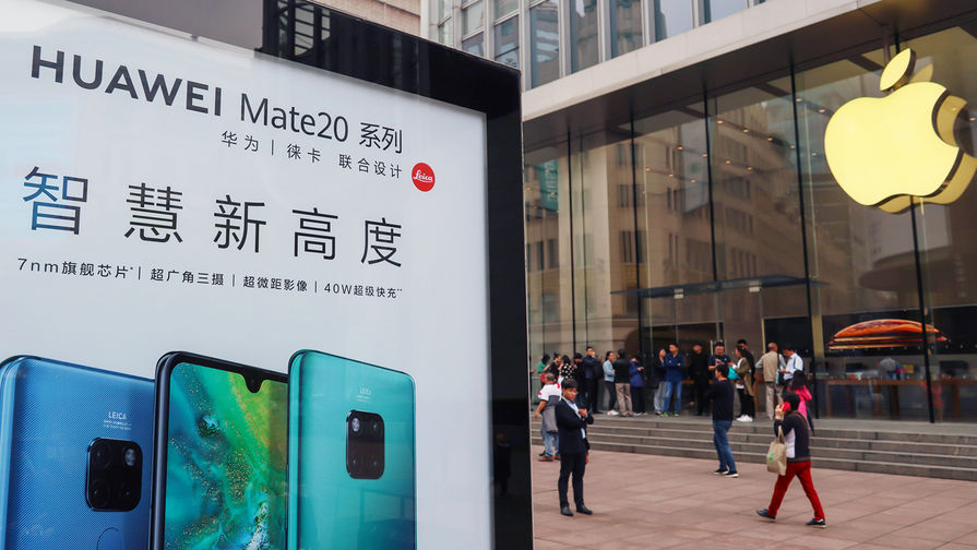 Реклама смартфонов Huawei на против фирменного магазина Apple в Шанхае, октябрь 2018 года