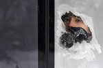 Пассажир смотрит через замороженное окно городского автобуса при температуре воздуха около -27 градусов Цельсия в Красноярске, 8 декабря 2023 года
