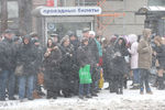 Жители города во время снегопада на одной из улиц города. 