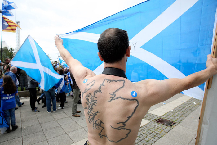 Сторонник независимости Шотландии с татуировкой в виде Шотландии на митинге в Глазго