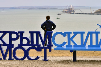 Скамейка «Крымский мост» на фоне железнодорожной арки моста через Керченский пролив, август 2017 года