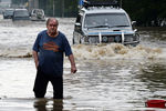 Мужчина и автомобили на затопленной улице Уссурийска