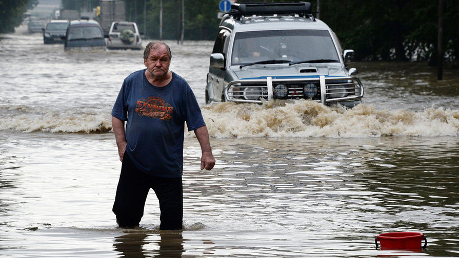 Мужчина и автомобили на&nbsp;затопленной улице Уссурийска