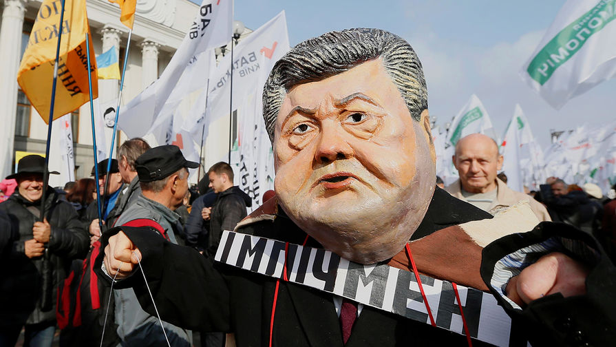 Человек в маске с лицом президента Украины Петра Порошенко во время протестной акции сторонников экс-главы Одесской области Михаила Саакашвили около здания Рады в Киеве, 17 октября 2017 года