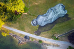 Аэрография художника Сайпе, изображающая пэт-бутылку, оставленную на траве, в парке Бурже в Лозанне, 16 июня 2023 года