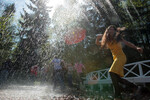 Посетители Государственного музея-заповедника «Петергоф» пробегают под струями воды фонтана-шутихи «Дубок» в Нижнем парке, 2011 год