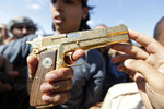 20 октября. Боец повстанческих сил показывает журналистам золотой пистолет Муамара Каддафи, убитого накануне. Смерть Каддафи положила конец вооруженному противостоянию в Ливии и вызвала неоднозначную оценку мирового сообщества, часть которого расценила убийство ливийского лидера как хладнокровную внесудебную расправу.