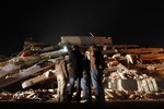 23 октября. Выжившие после землетрясения, потрясшего Турцию, стоят у развалин.