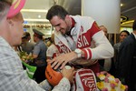 Волейболист Александр Волков подписывает мяч болельщику 